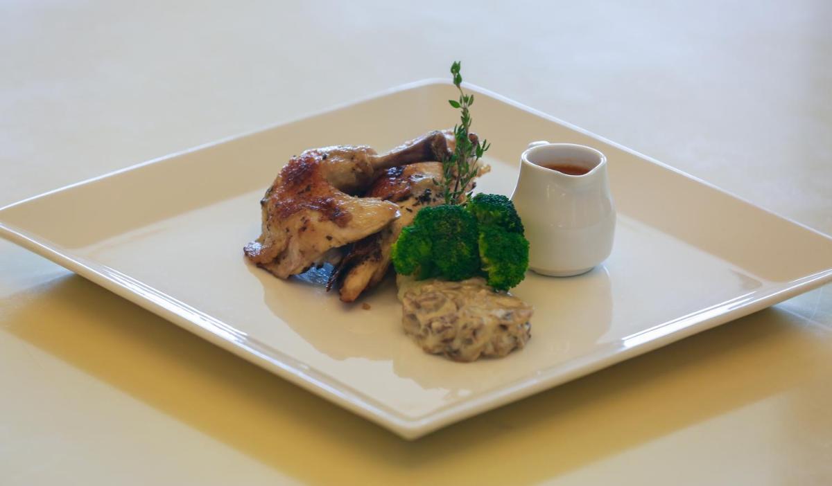 a plate of food with chicken and broccoli on a table at Trident Agra in Agra