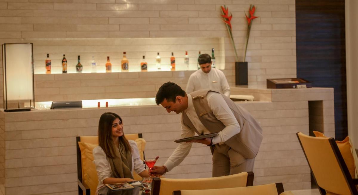 a man handing a woman a drink in a restaurant at Trident Agra in Agra