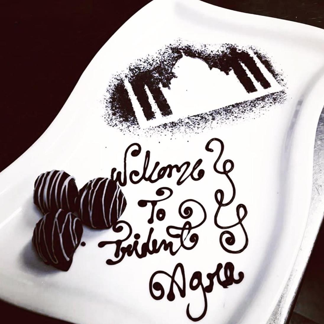 a plate with a chocolate cake and a sign that says welcome to mymite at Trident Agra in Agra