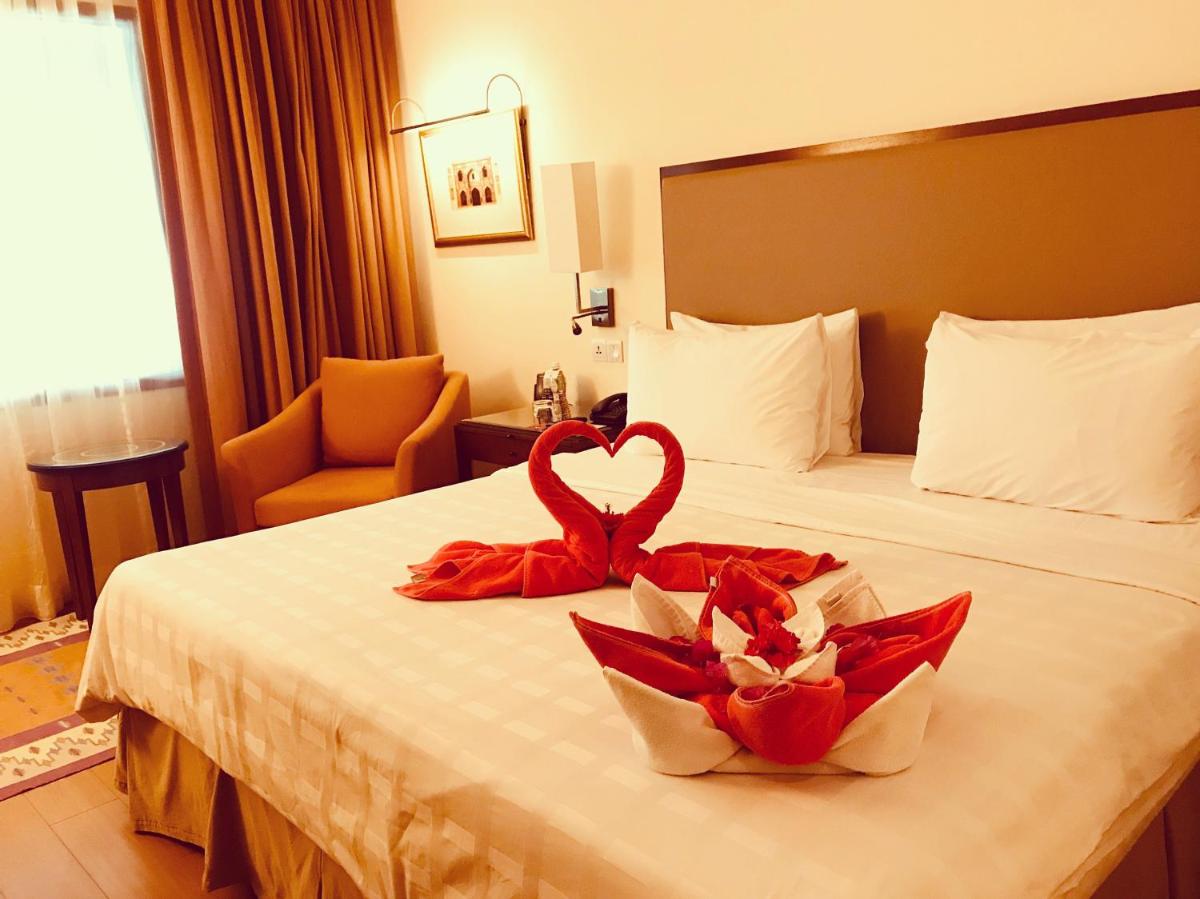 a hotel room with two hearts on a bed at Trident Agra in Agra