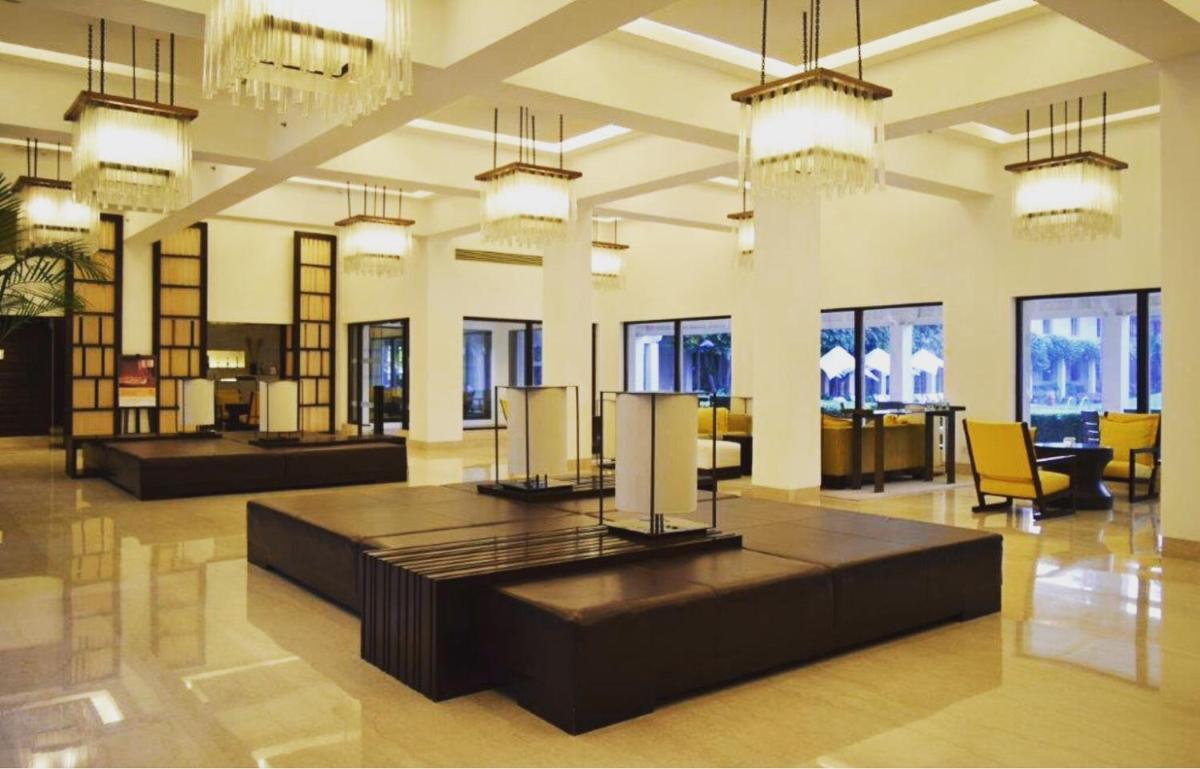 a large room with tables and chairs and chandeliers at Trident Agra in Agra