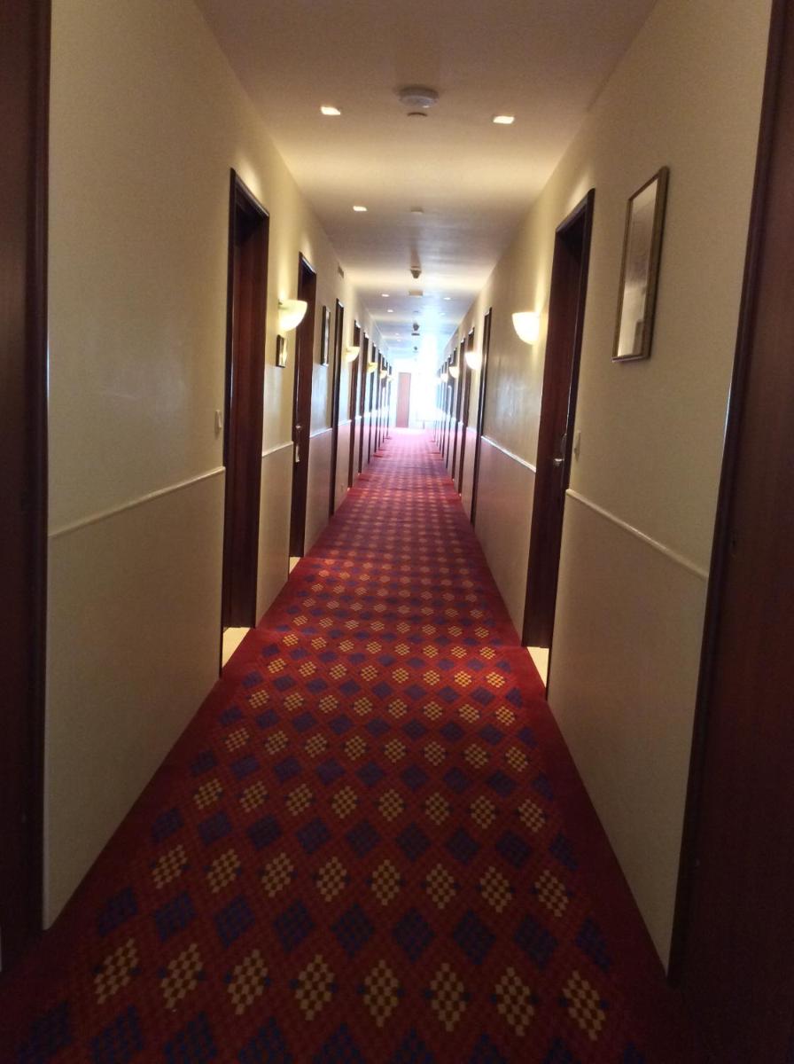 a long hallway of a hotel with a red carpet at Trident Agra in Agra