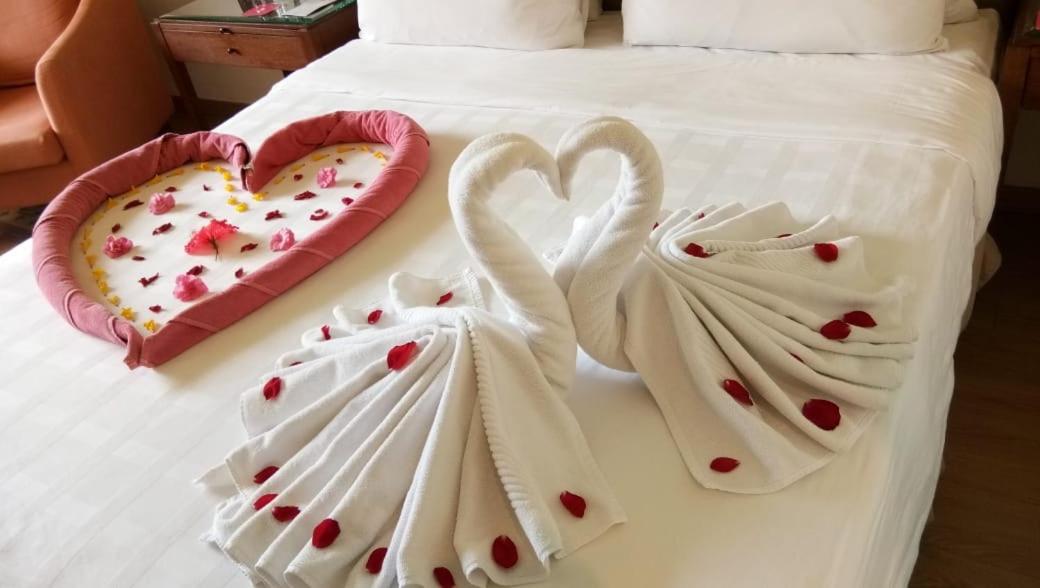 two swans shaped towels on a bed with hearts at Trident Agra in Agra