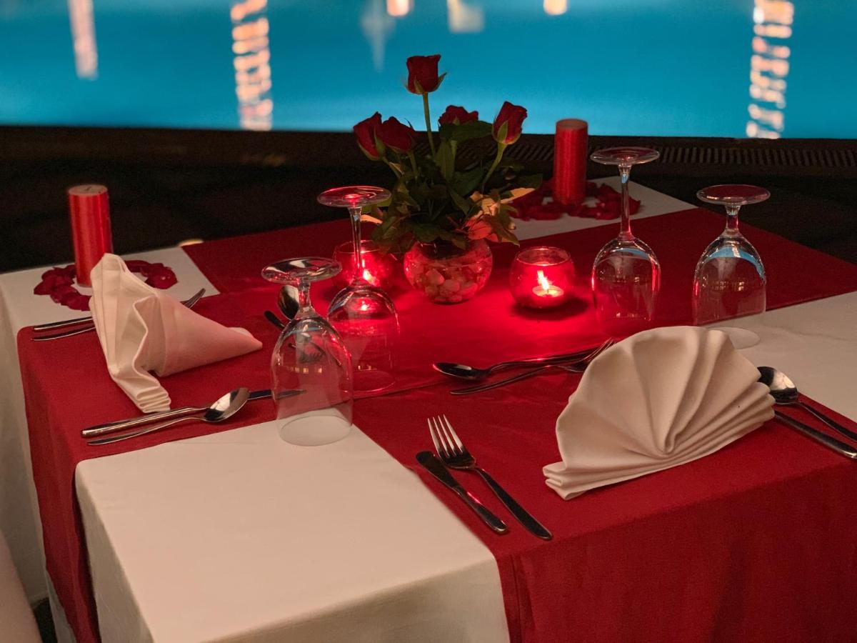 a red and white table with candles and red napkins at Trident Agra in Agra