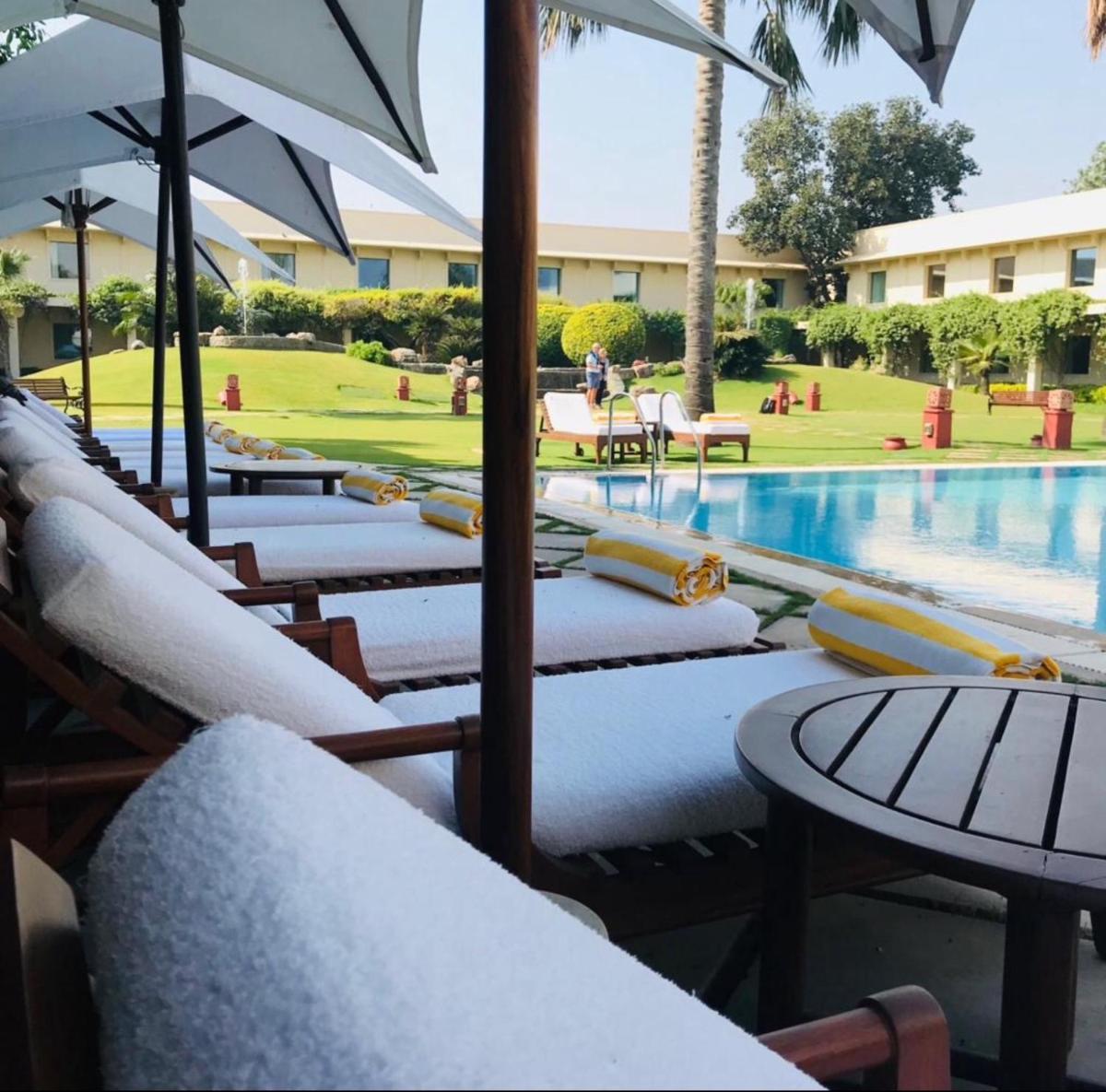 a row of chairs and tables next to a swimming pool at Trident Agra in Agra