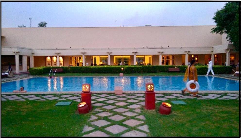 a large building with a large swimming pool at Trident Agra in Agra