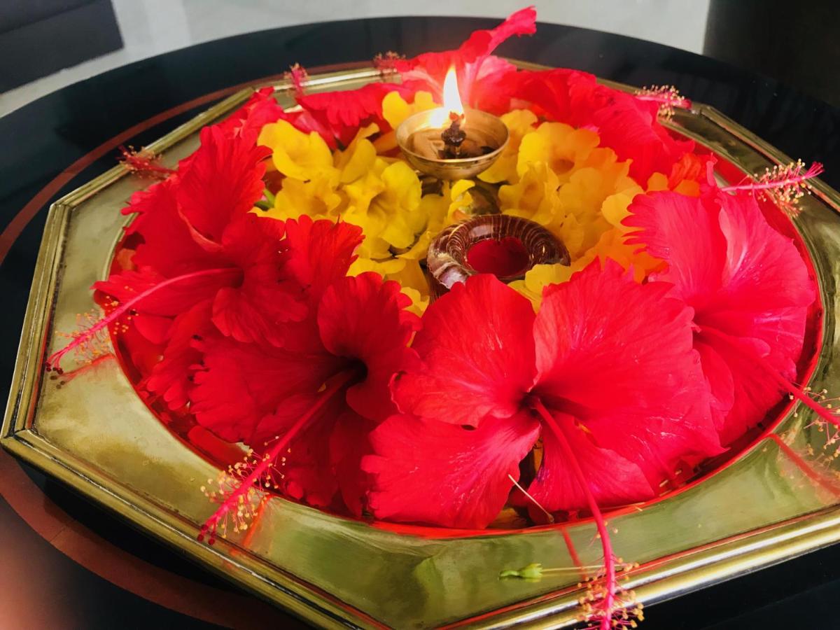a centerpiece of red and yellow flowers with a candle at Trident Agra in Agra
