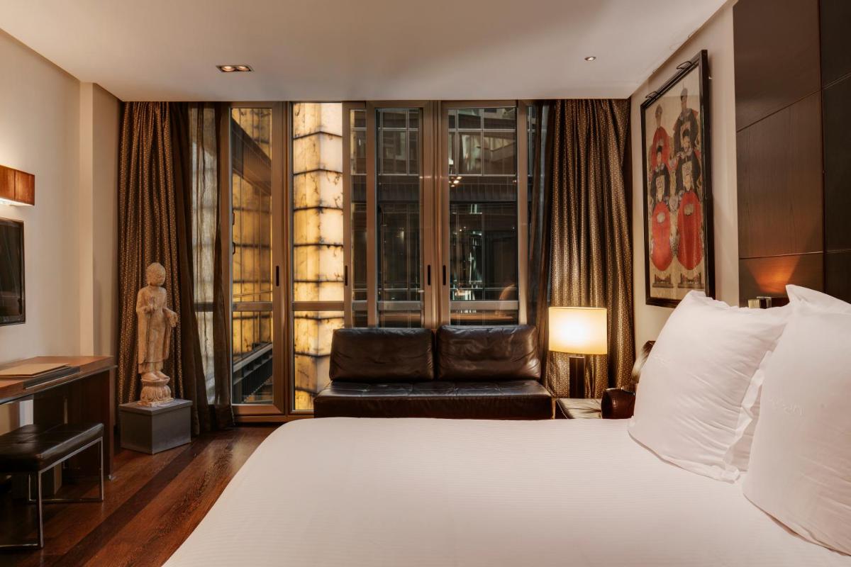 una habitación de hotel con una cama y una silla en Hotel Urban, a Small Luxury Hotel of the World, en Madrid