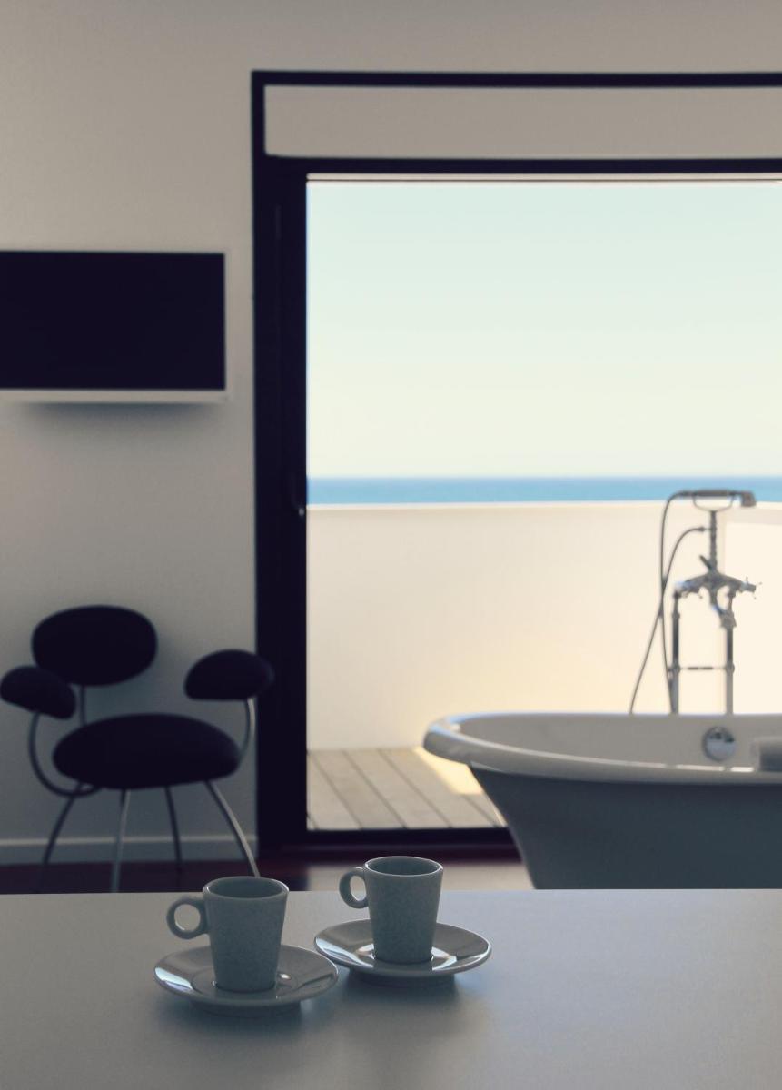 une salle de bain avec une baignoire et deux tasses sur une table dans l'établissement Le Grand Hotel de la Plage, à Biscarrosse-Plage 70 autres photos