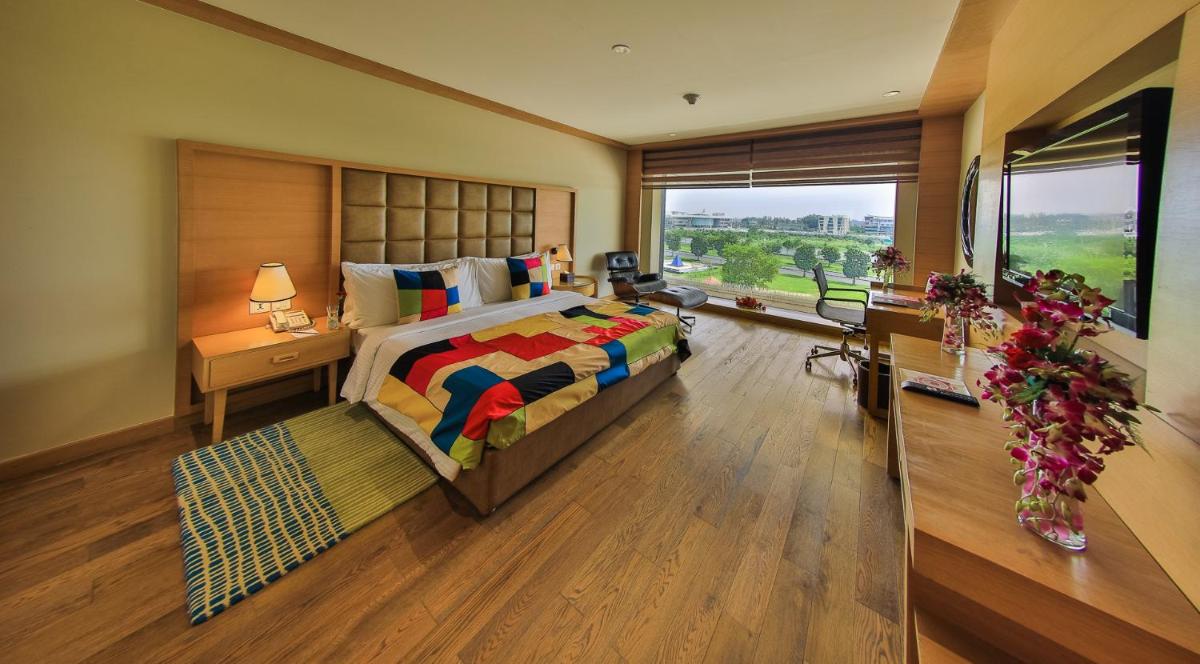 a bedroom with a large bed and a large window at The Lalit Chandigarh in Chandīgarh