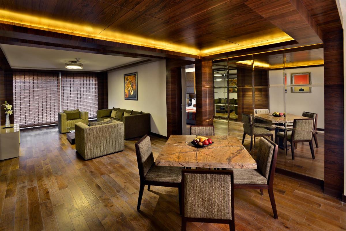 a dining room with a table and chairs at The Lalit Chandigarh in Chandīgarh