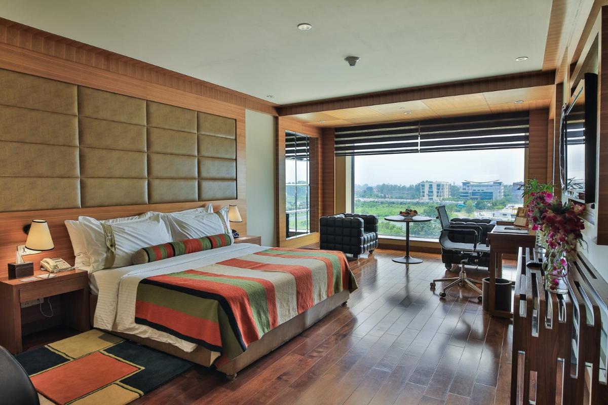 a hotel room with a bed and a desk and a window at The Lalit Chandigarh in Chandīgarh