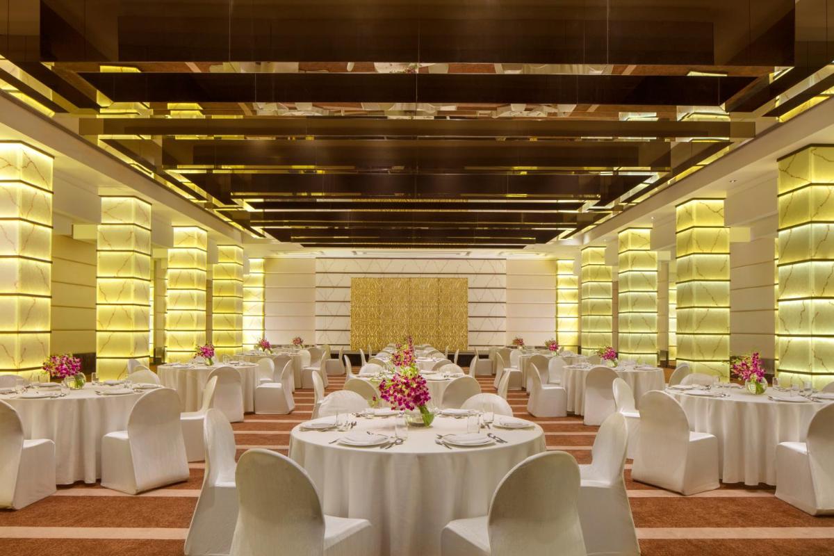a banquet hall with white tables and white chairs at Radisson Blu Atria Bengaluru in Bengaluru a banquet hall with white tables and white chairs at Radisson Blu Atria Bengaluru in Bengaluru