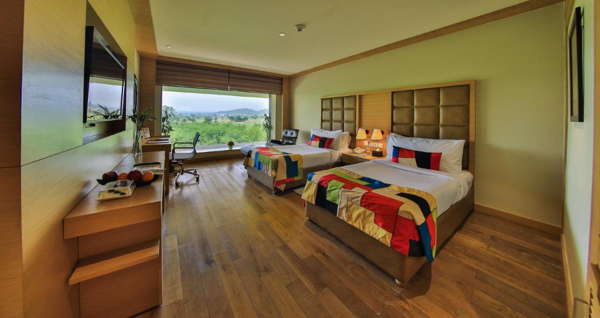 a bedroom with two beds and a large window at The Lalit Chandigarh in Chandīgarh