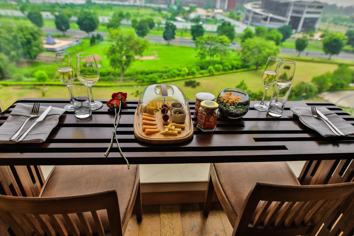 a table with a tray of food and wine glasses at The Lalit Chandigarh in Chandīgarh