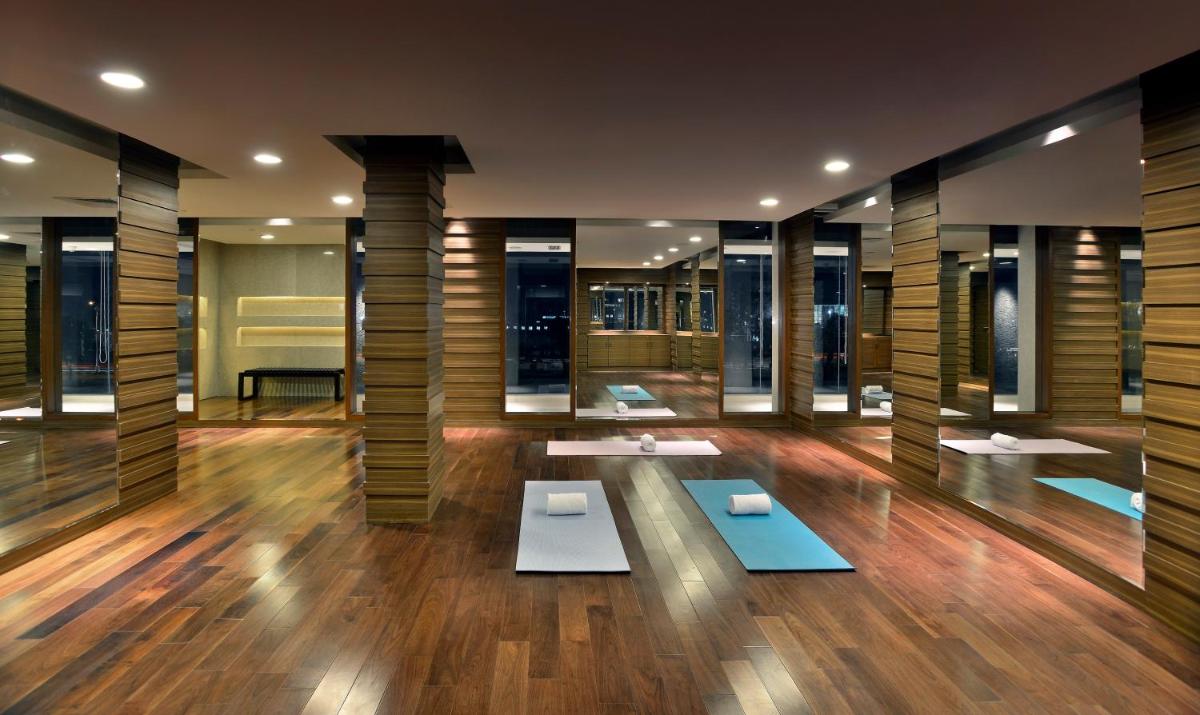 a lobby with tables and windows in a building at The Lalit Chandigarh in Chandīgarh