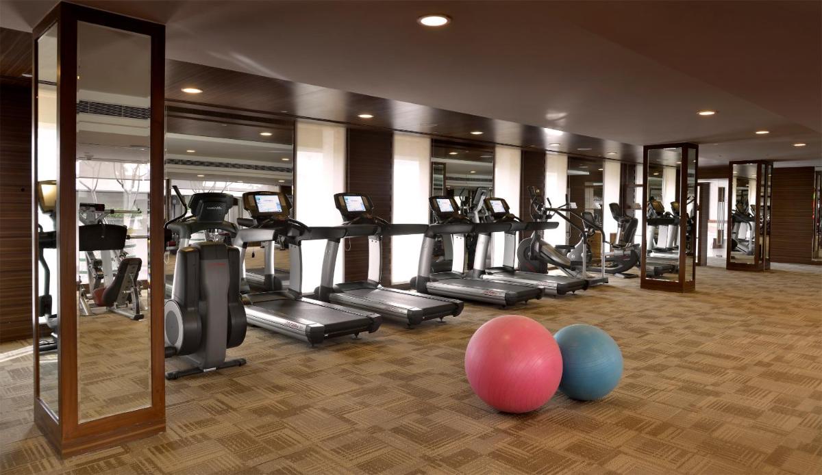 a gym with a bunch of tread machines and balloons at The Lalit Chandigarh in Chandīgarh