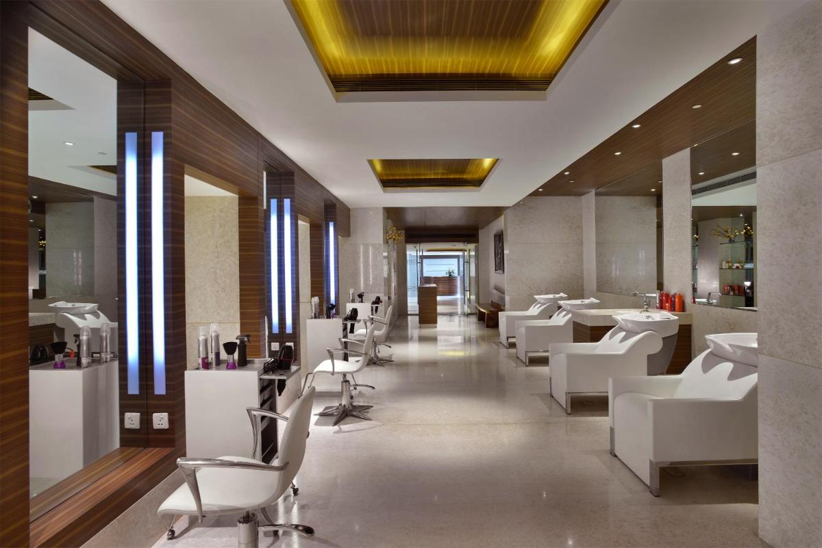 a hair salon with white chairs and tables at The Lalit Chandigarh in Chandīgarh