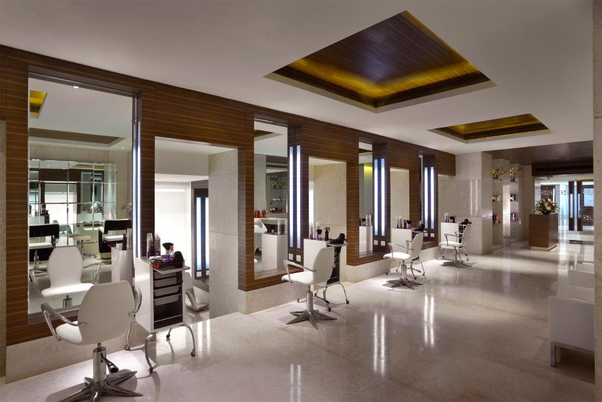 a hair salon with white chairs and mirrors at The Lalit Chandigarh in Chandīgarh