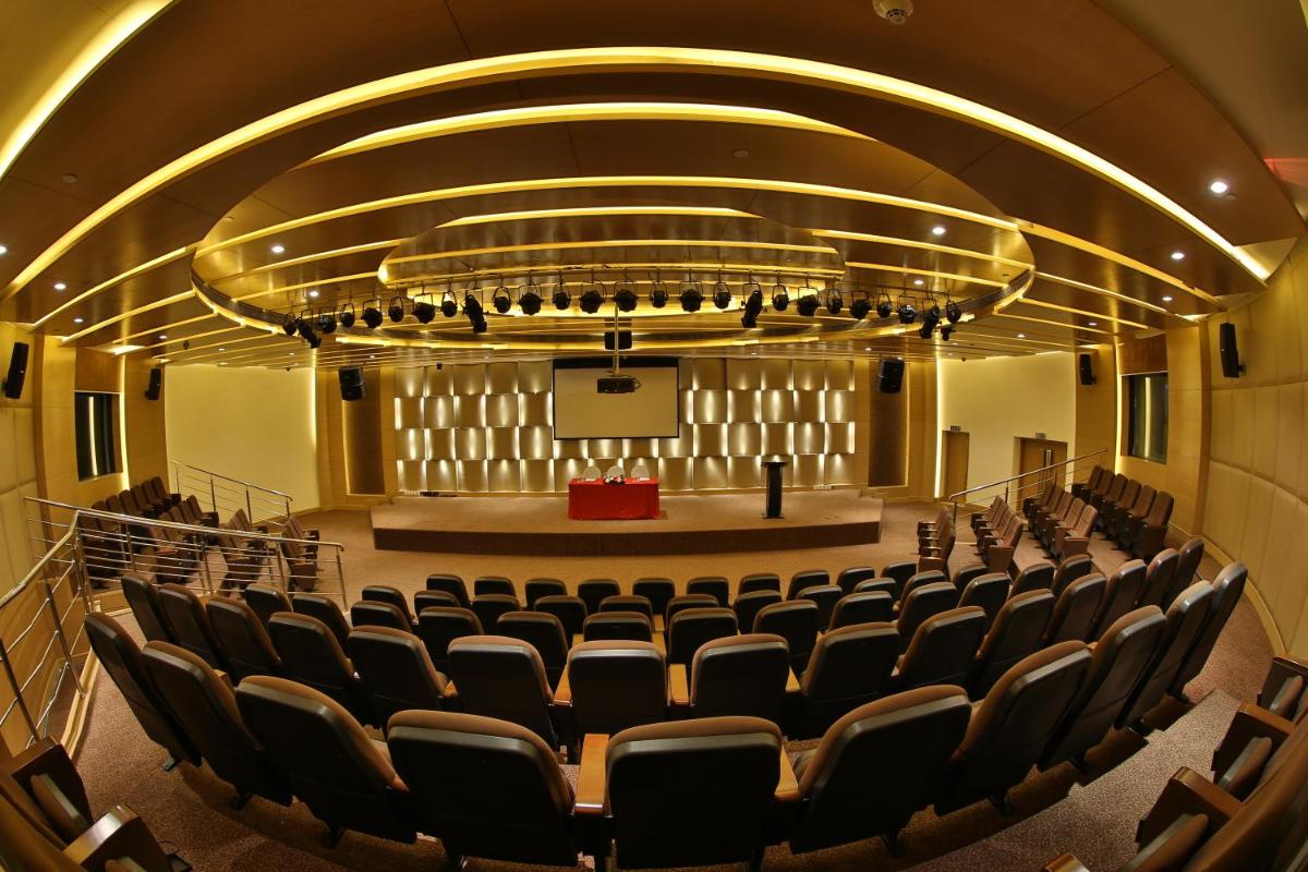 a large auditorium with chairs and a stage at The Lalit Chandigarh in Chandīgarh
