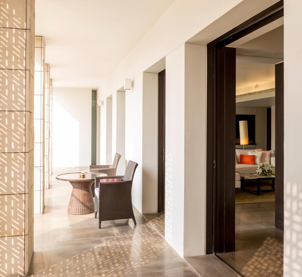 a hallway with a table and chairs in a room at The Lodhi – A member of The Leading Hotels Of The World in New Delhi