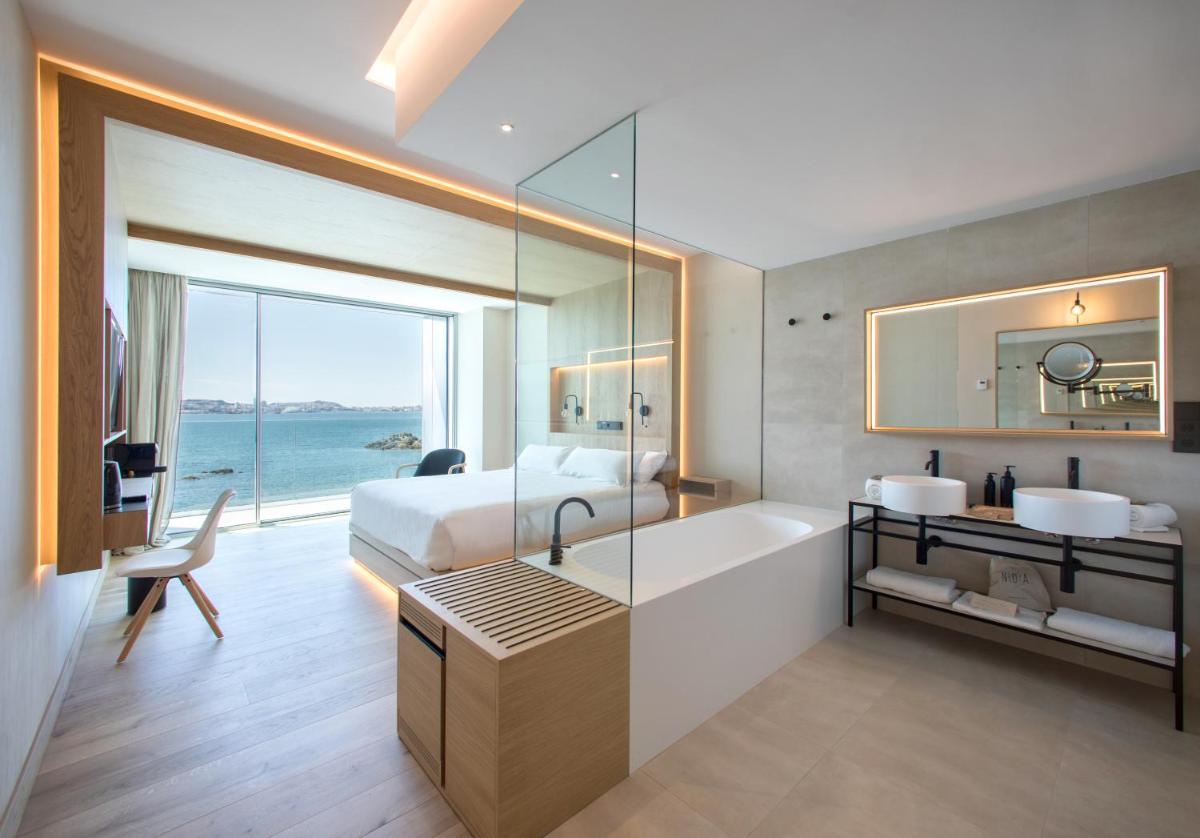 Habitación de hotel con cama, bañera y baño. en Noa Boutique Hotel, en Santa Cruz de Oleiros
