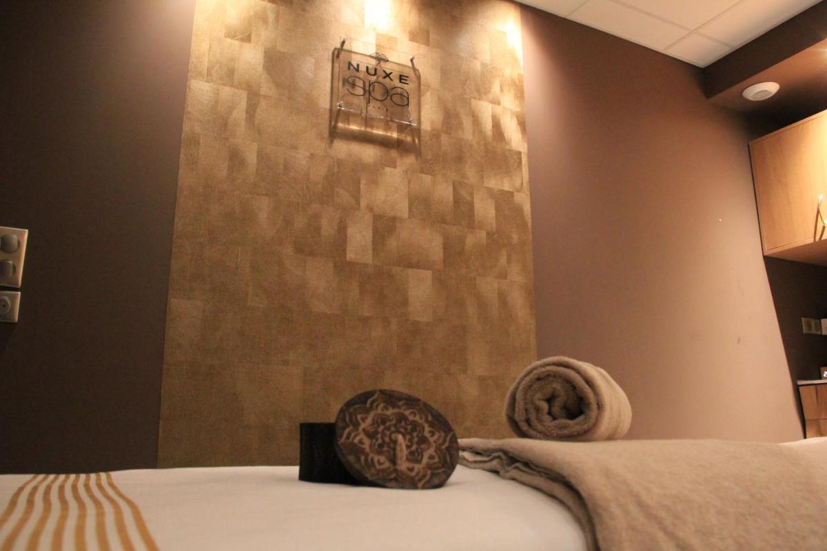 Un ou plusieurs lits dans un hébergement de l'établissement Le Diana Hôtel & Spa