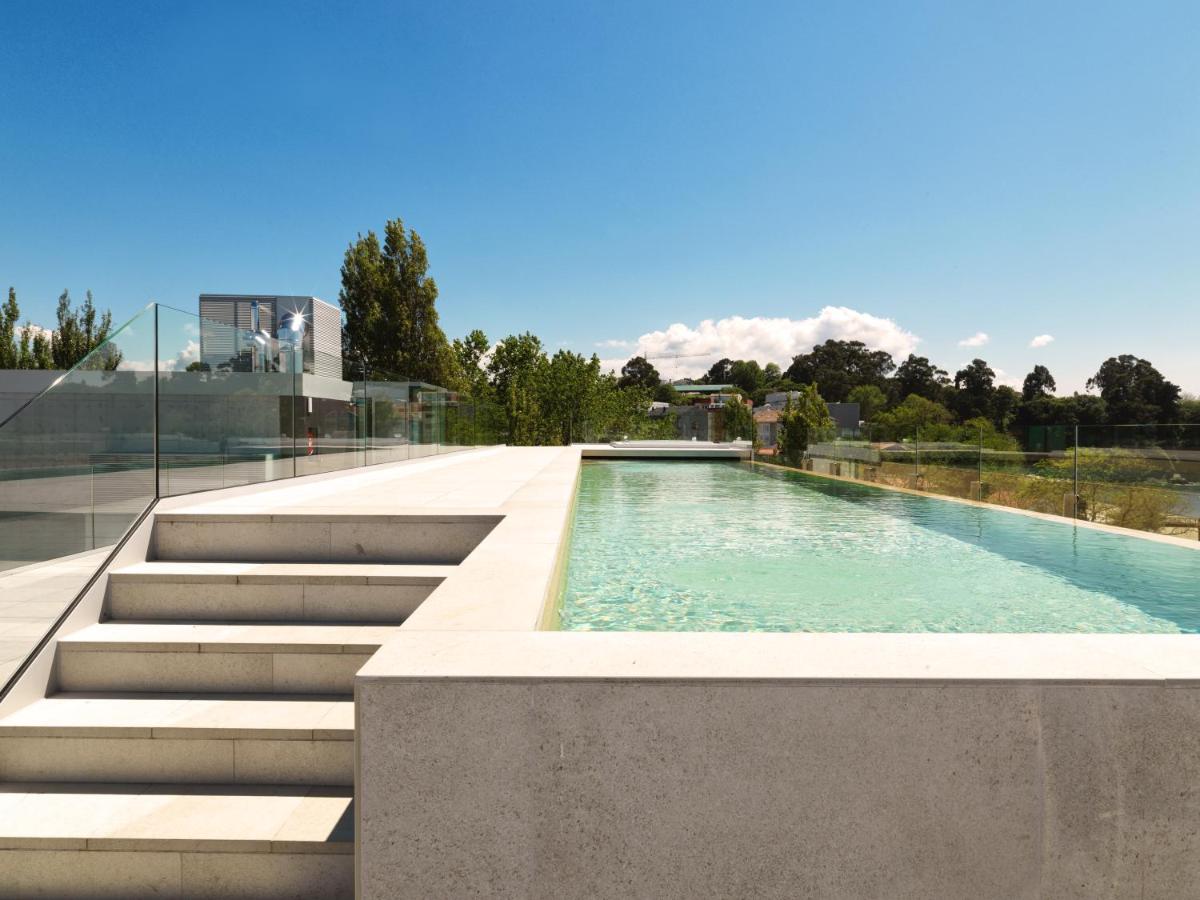 Una piscina con escaleras al lado de un edificio. en Noa Boutique Hotel, en Santa Cruz de Oleiros