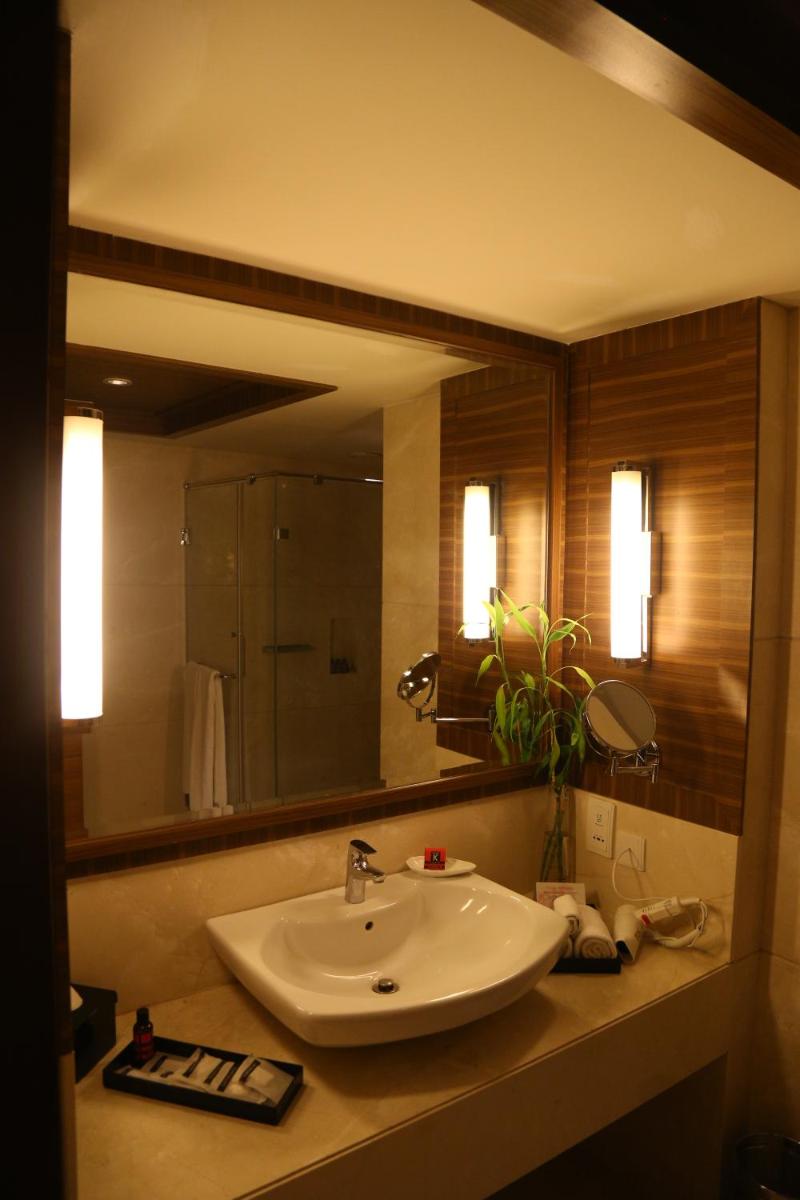 a bathroom with a sink and a large mirror at The Lalit Chandigarh in Chandīgarh