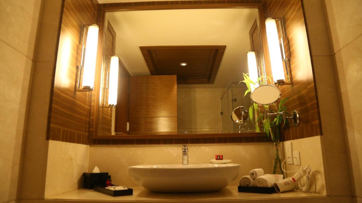 a bathroom with a sink and a large mirror at The Lalit Chandigarh in Chandīgarh