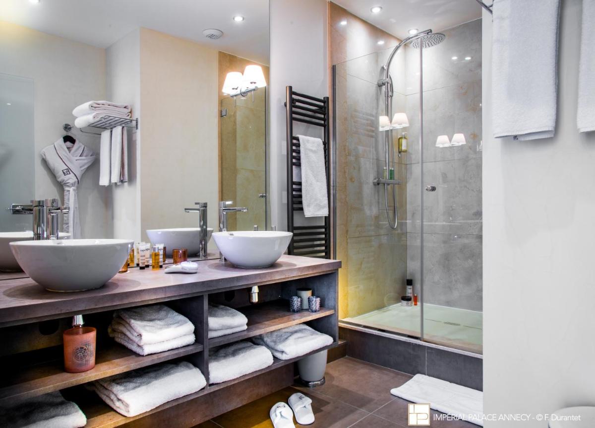 une salle de bain avec deux lavabos et une douche dans l'établissement Impérial Palace, à Annecy