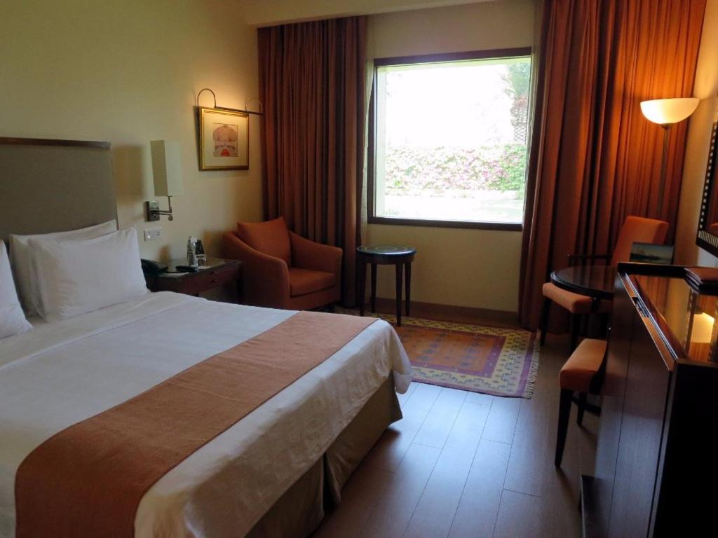 a hotel room with a bed and a window at Trident Agra in Agra