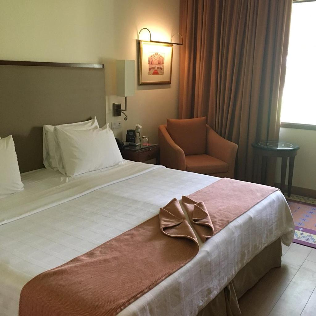 a hotel room with a large bed with a bow on it at Trident Agra in Agra