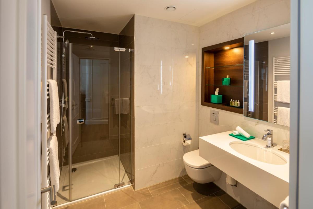 ein Badezimmer mit Dusche, Toilette und Waschbecken in der Unterkunft Fraser Suites Hamburg in Hamburg ein Badezimmer mit Dusche, Toilette und Waschbecken in der Unterkunft Fraser Suites Hamburg in Hamburg