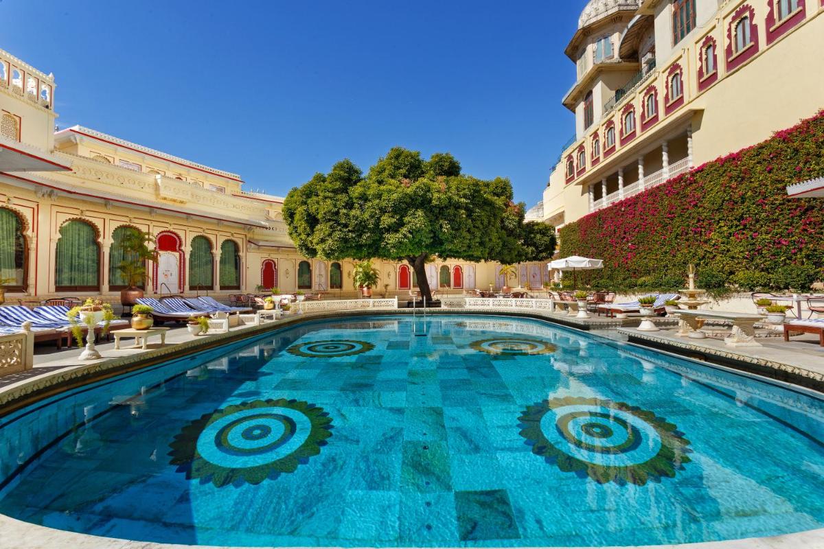 a large swimming pool in a courtyard with a building at Shiv Niwas Palace by HRH Group of Hotels in Udaipur