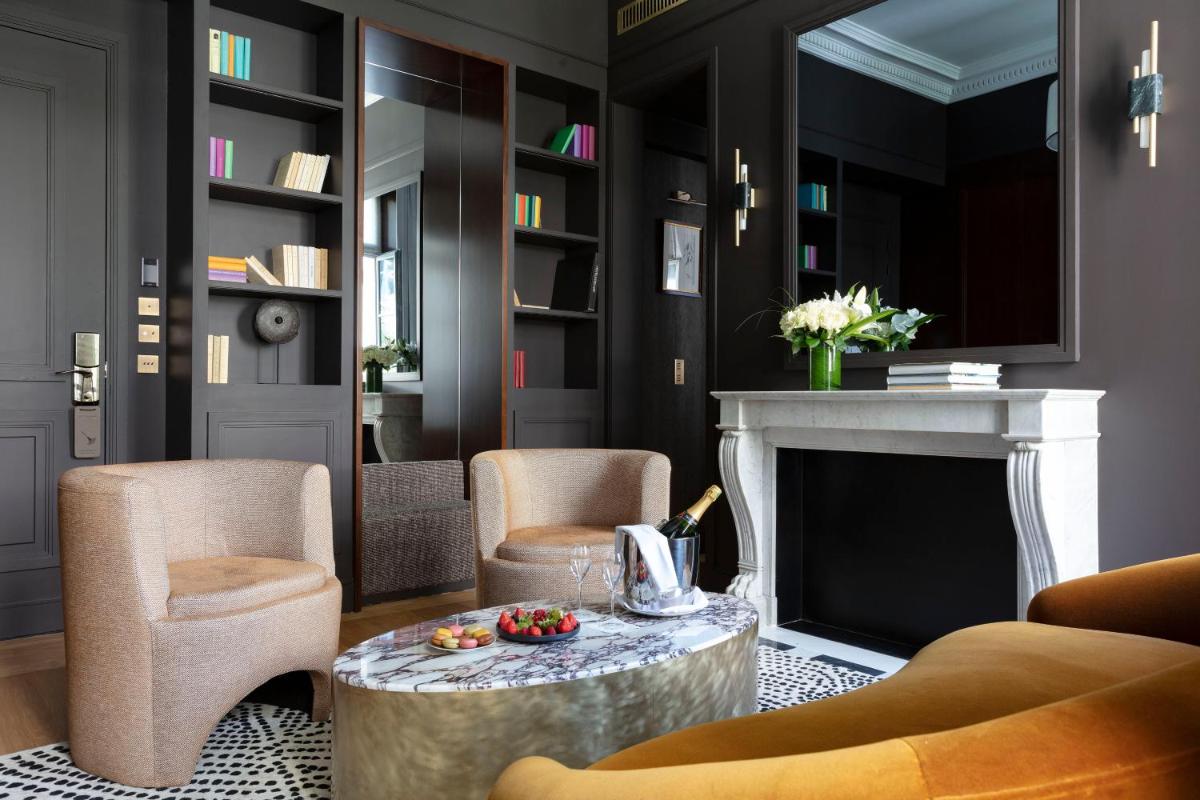 - un salon avec une cheminée, des chaises et une table dans l'établissement Les Jardins du Faubourg Hotel & Spa by Shiseido, à Paris