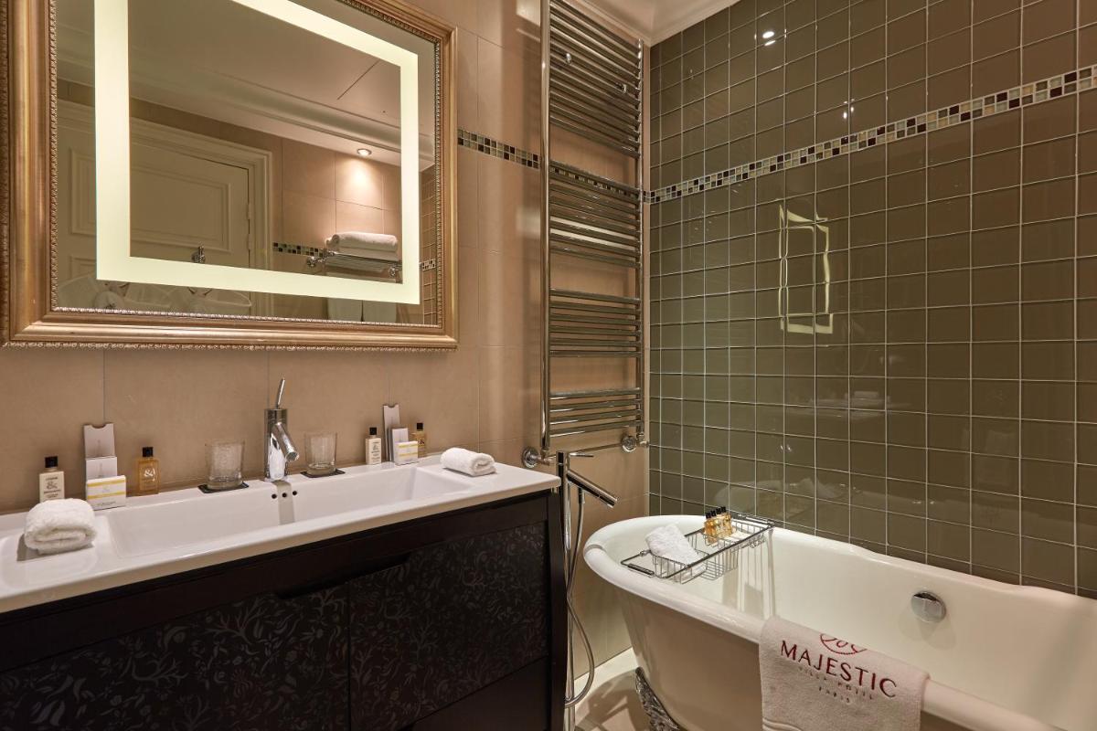 une salle de bain avec un lavabo, une baignoire et un miroir dans l'établissement Majestic Apartments Champs Elysées, à Paris 18 autres photos