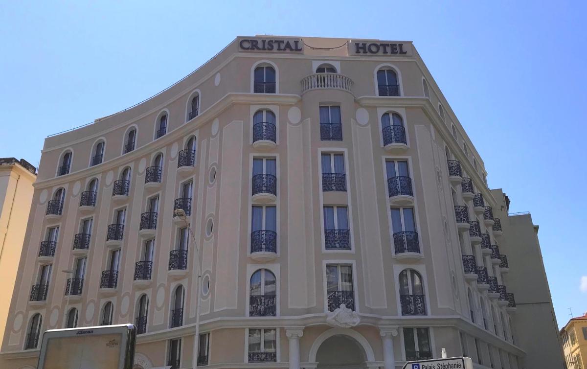 un grand bâtiment blanc avec une enseigne dessus dans l'établissement Cristal Hôtel & Spa, à Cannes