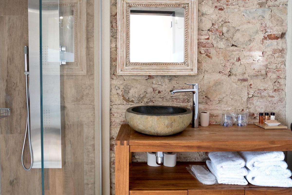 Un baño con un lavabo de piedra y un espejo. en Sa Voga Hotel & Spa, en Arenys de Mar