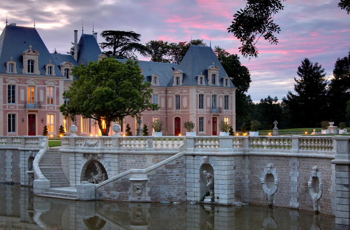 un manoir avec un pont dans l'eau devant dans l'établissement Alexandra Palace - La Maison Younan, à Mazières-en-Gâtine