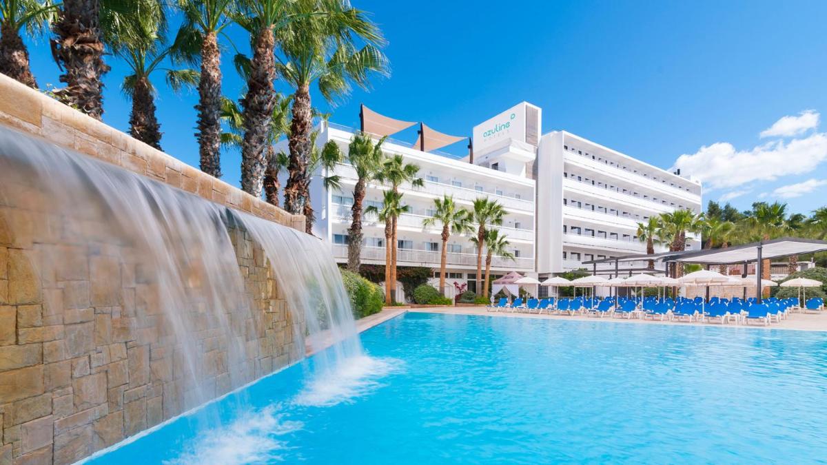 una piscina con cascada frente a un hotel en azuLine Hotel Bergantin, en Bahía de San Antonio