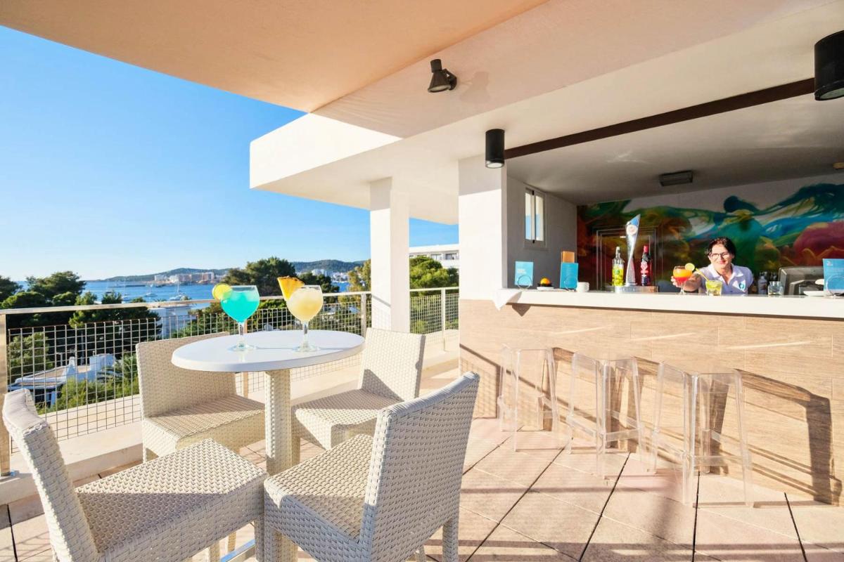 un patio con sillas y una mesa con bebidas. en azuLine Hotel Bergantin, en Bahía de San Antonio