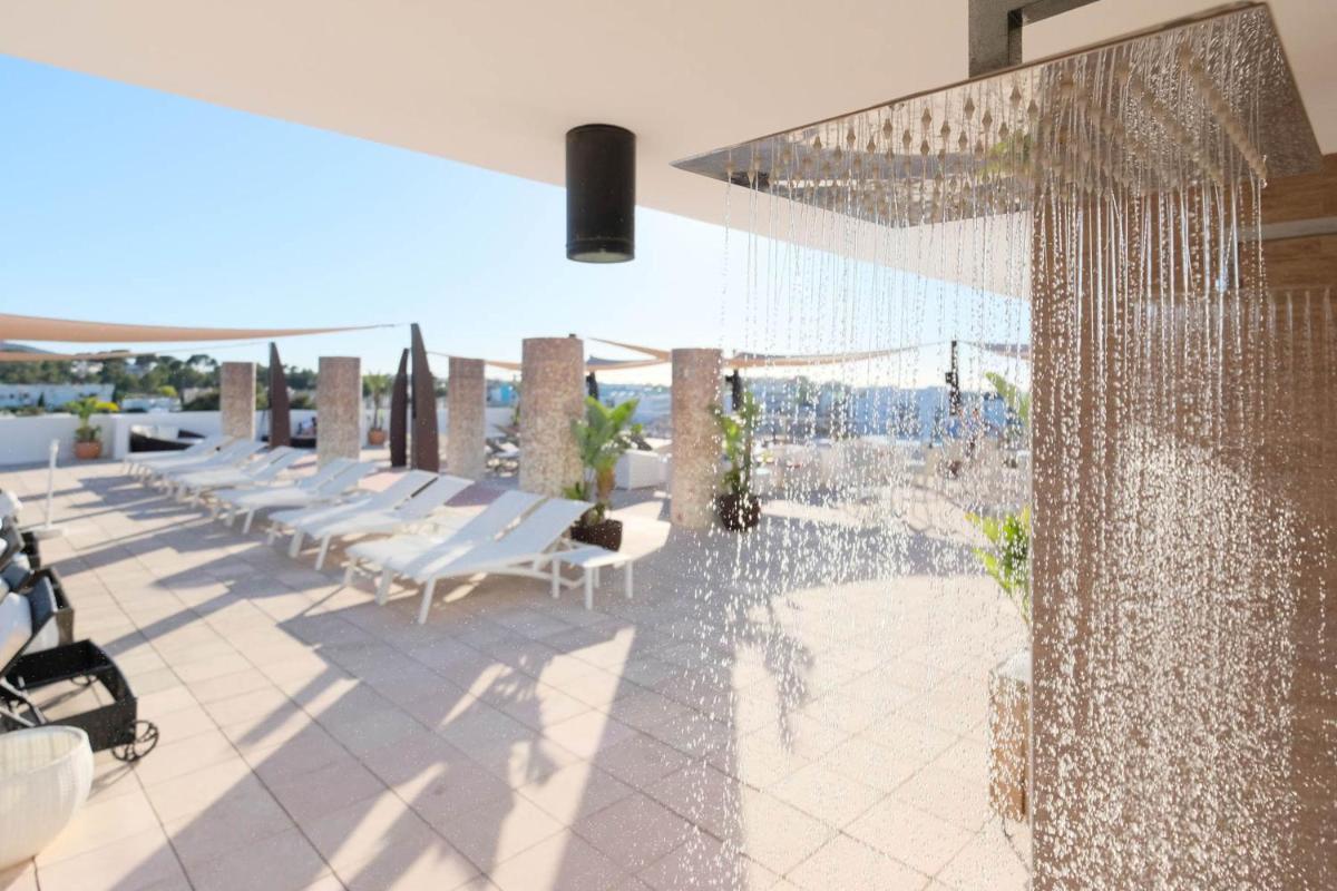 una piscina con tumbonas y vistas al océano en azuLine Hotel Bergantin, en Bahía de San Antonio