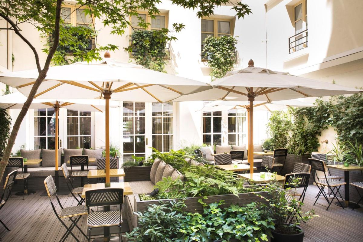 une terrasse extérieure avec tables, chaises et parasols dans l'établissement Hôtel D'Aubusson, à Paris