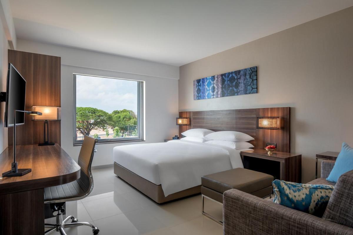a hotel room with a bed and a desk and a couch at The Residency Towers, Rameswaram in Rāmeswaram