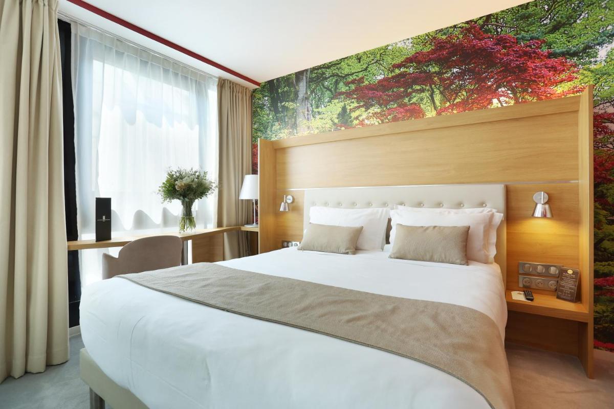 une chambre avec un grand lit blanc avec un tableau sur le mur dans l'établissement Jardins de Mademoiselle Hôtel & Spa, à Paris