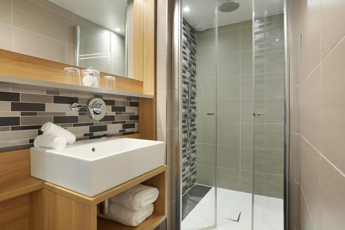 une salle de bain avec lavabo et douche dans l'établissement Jardins de Mademoiselle Hôtel & Spa, à Paris
