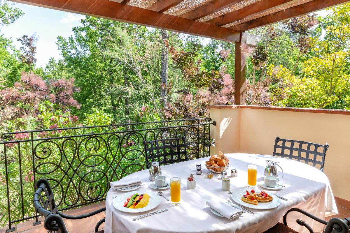 une table avec des assiettes de nourriture sur un balcon dans l'établissement Terre Blanche Hotel Spa Golf Resort, à Tourrettes 54 autres photos