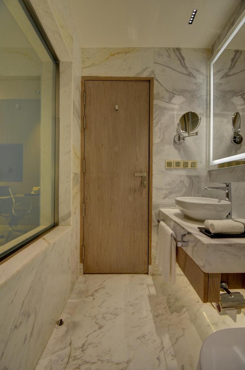 a bathroom with a sink and a wooden door at Vividus in Bengaluru a bathroom with a sink and a wooden door at Vividus in Bengaluru