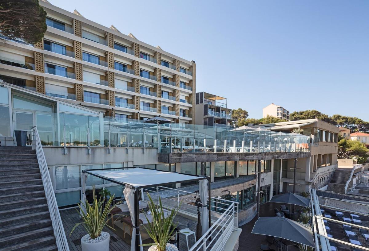 - un bâtiment avec des escaliers et une table devant dans l'établissement Thalazur Bandol Ile Rousse - Hôtel & Spa, à Bandol